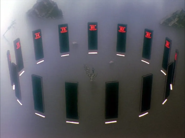 A scene of the SEELE meeting with monoliths arranged in a circle amidst dark fog